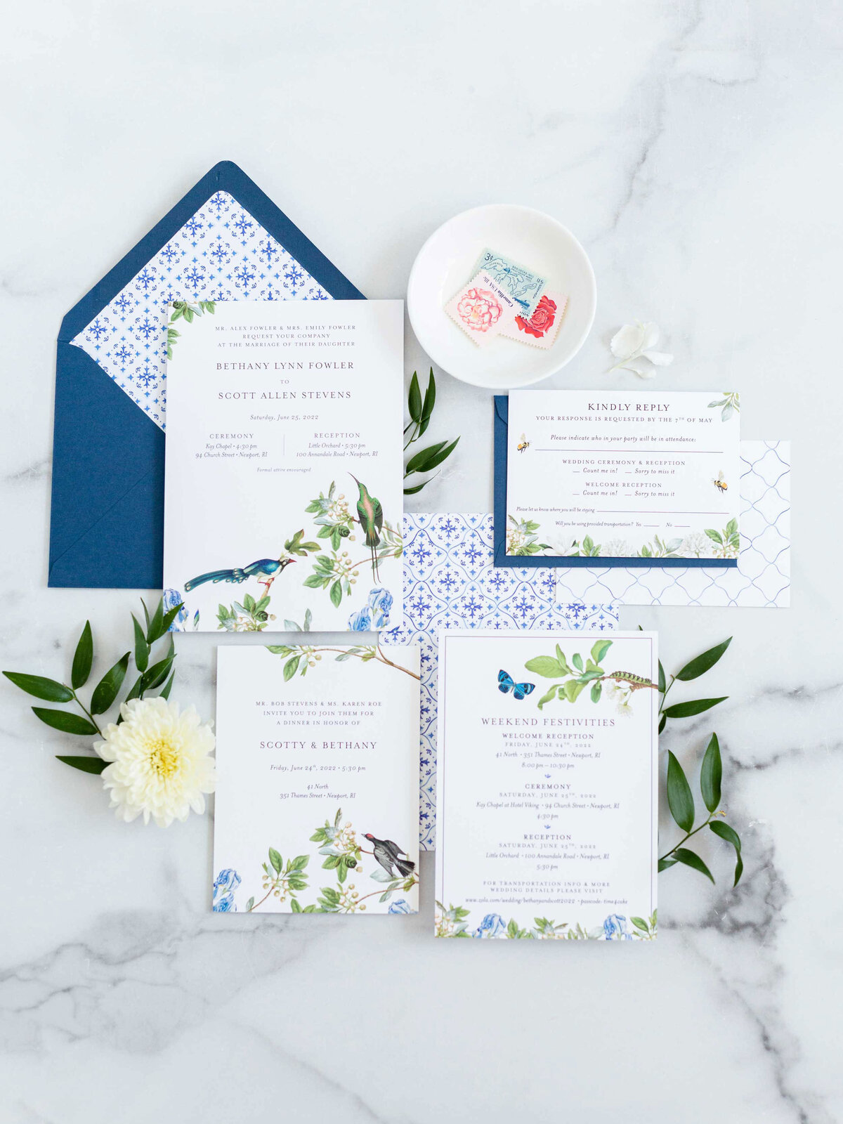 Botanical Invitation suite with birds and flowers. Suite shown on a marble background with blue envelope and Mediterranean tile envelope liner
