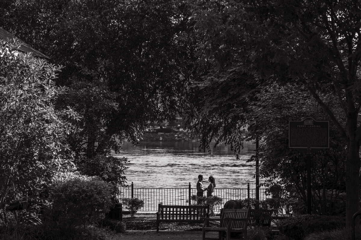 Couple in sunset silhouette during engagement session by Delaware River in New Hope Pennsylvania
