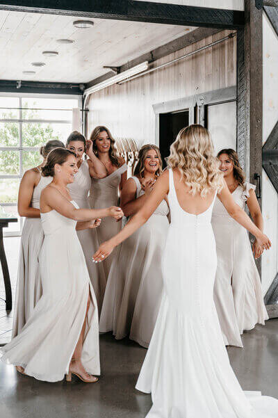 Bride showing dress to bridesmaids by best wedding planners in chicago