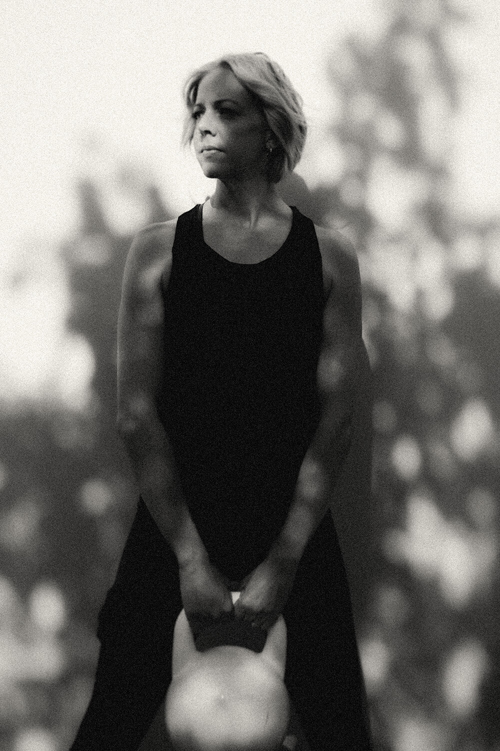 Monochrome branding portrait of a woman holding a kettlebell with quiet strength — styled by Sunshine Coast branding photographer.