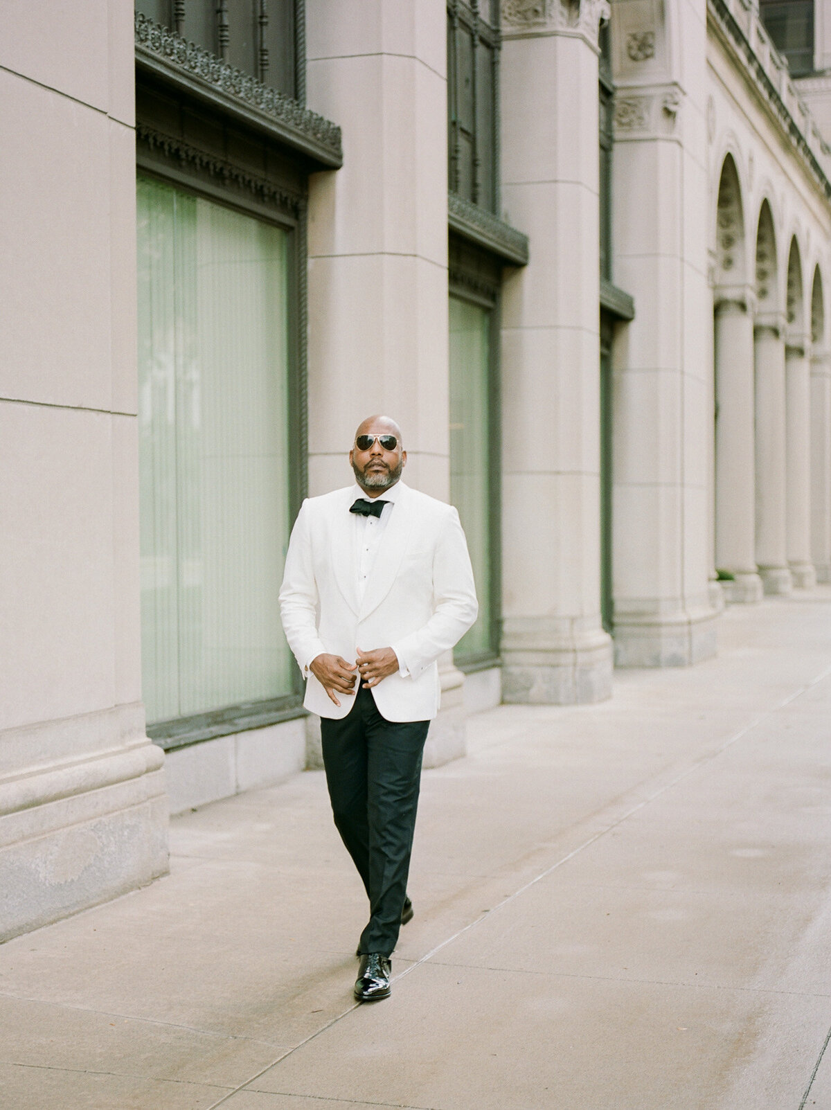 handsome black groom in white tux jacket with sunglasses in Detroit, Michigan