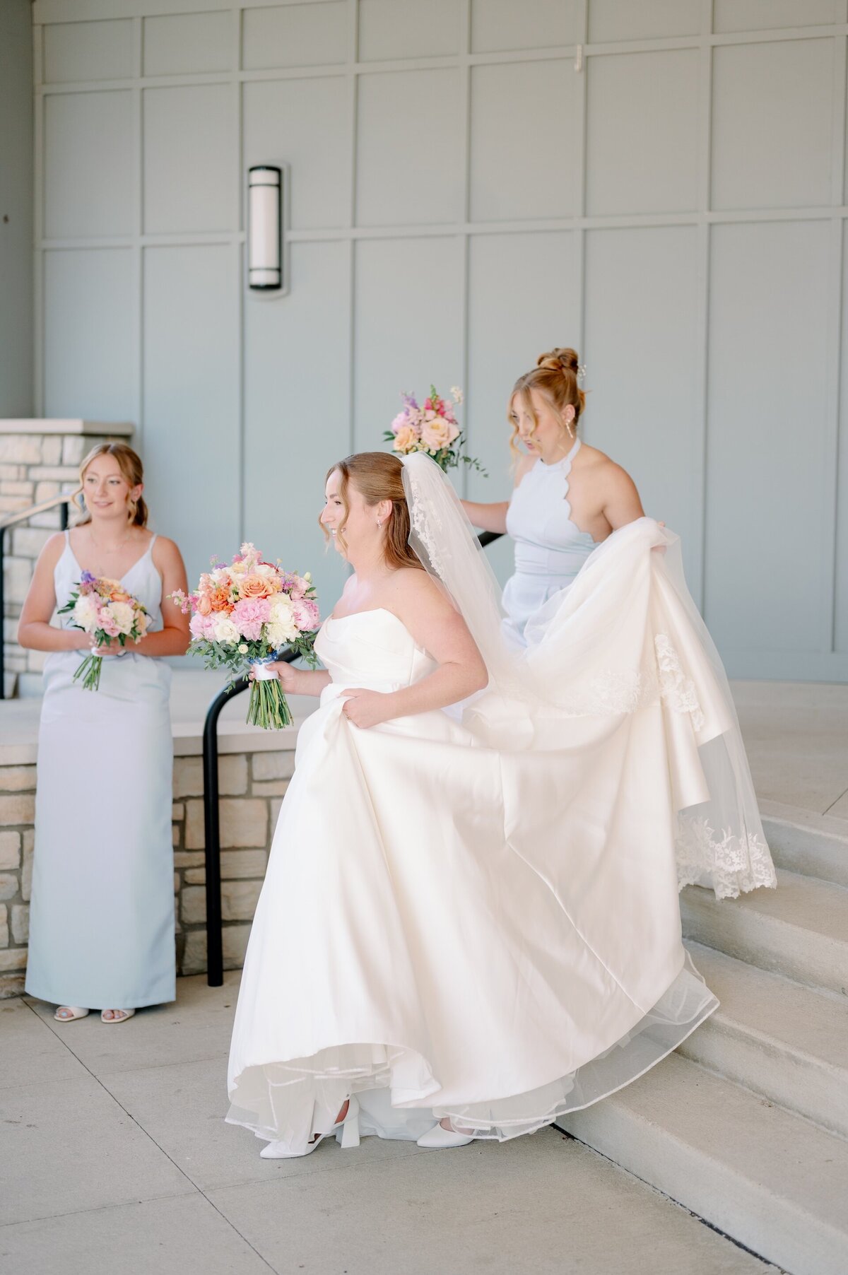 a bridesmaid helping a bride with her train