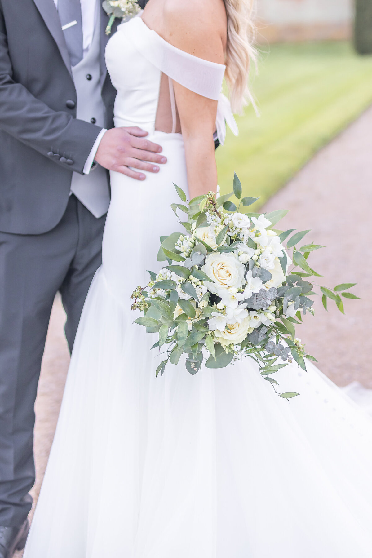 Close up of bride holding white rose bouquet