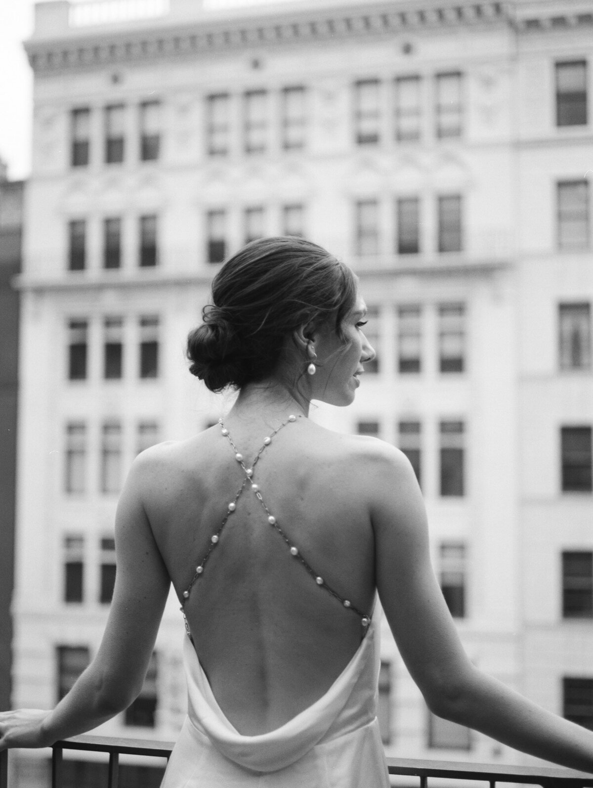 bride in backless wedding dress, pearl detail, on balcony at Shinola Hotel Detroit, Michigan
