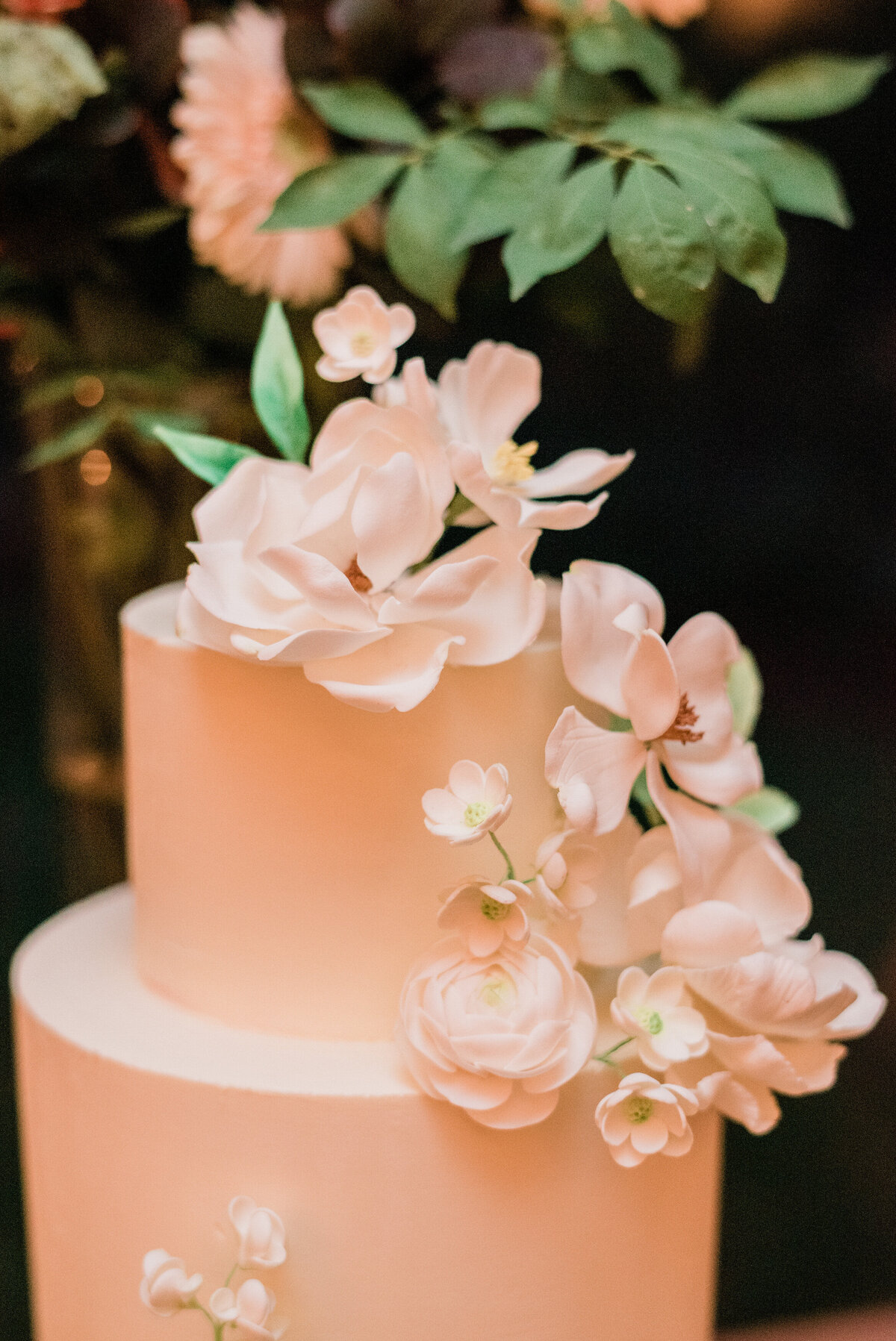 Wedding cake sits on reception table 