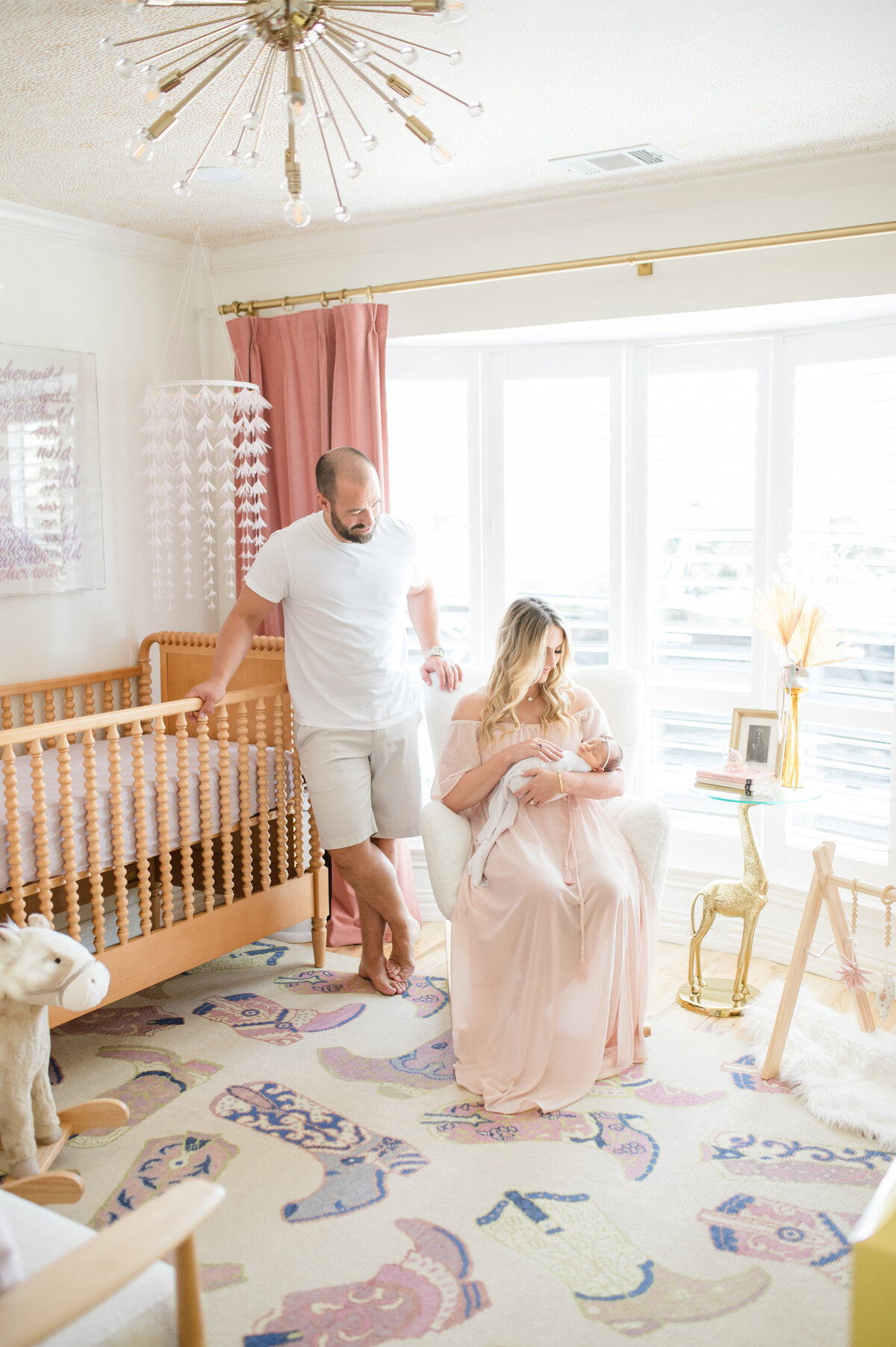 Parents looking at baby girl in nursery