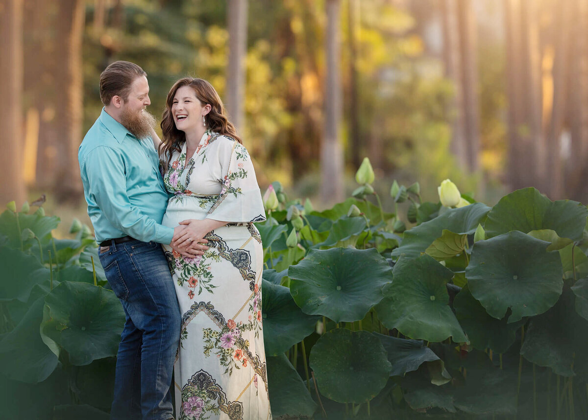 New mom and dad laughing at Echo Lake Park holding new baby bump by Los Angeles Maternity Photographer