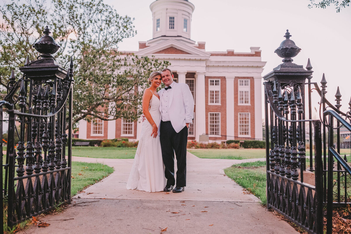 Bride and Groom posing for portrait in front of the Canton Courthouse Square in Mississippi.