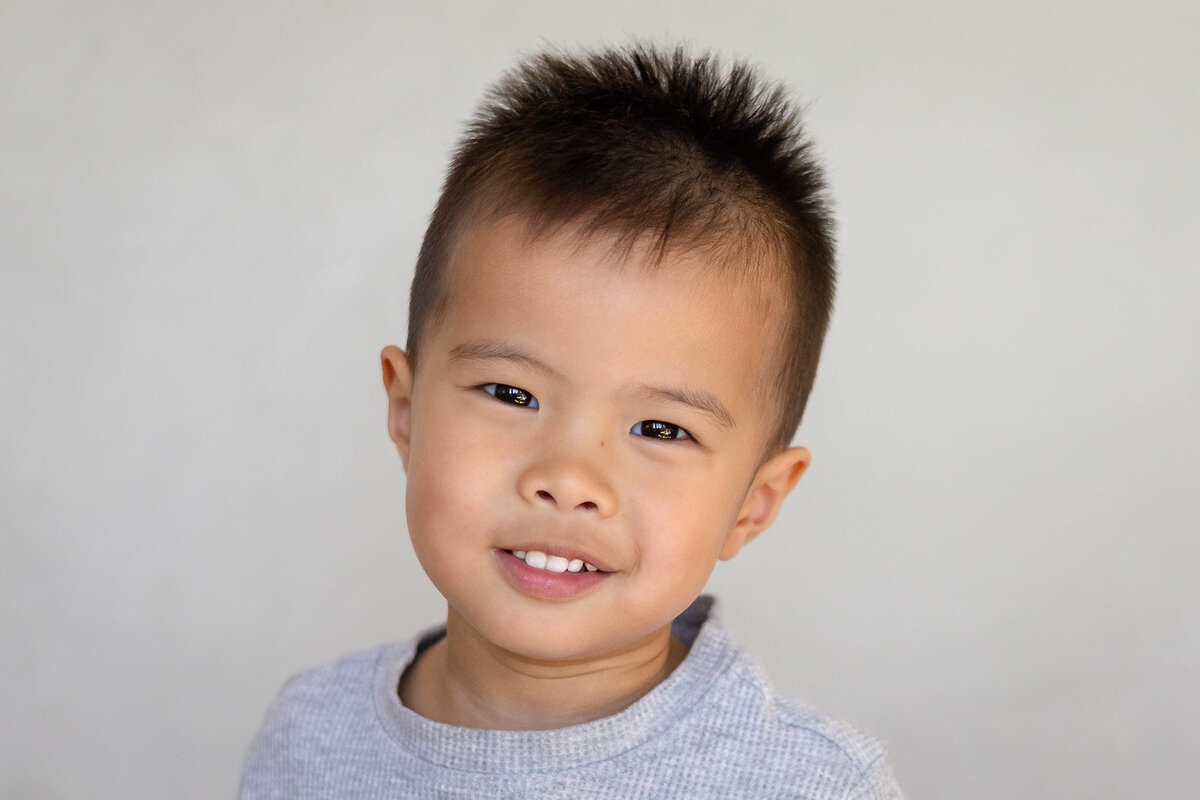 Preschool boy smiling confidently in gray shirt during Bay Area School Photography session at a Bay Area daycare – Ellobelle Photography