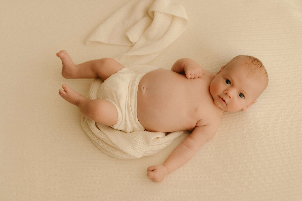 Newborn sleeping on beanbag in neutral wrap during Nashville TN studio newborn session