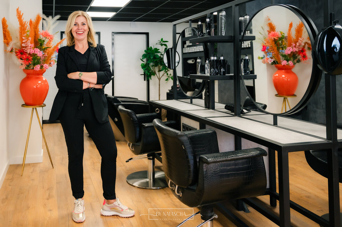Portret foto shoot bij Haarstudio Heesch met als decor de salon van een vaas met bloemen en kappers stoelen