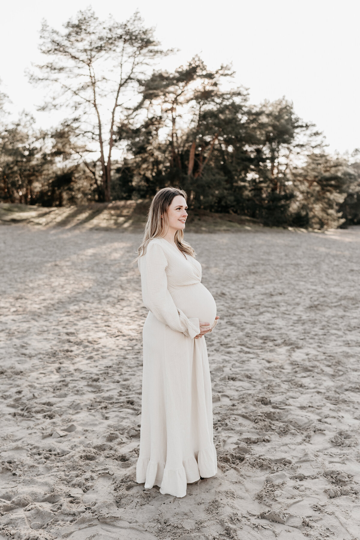 Zwangere vrouw in de Soesterduinen tijdens zonsondergang.