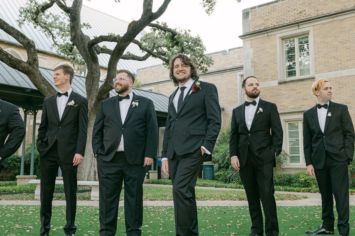 Classic photo of groom with groomsmen in tuxedos outside a San Antonio luxury wedding venue