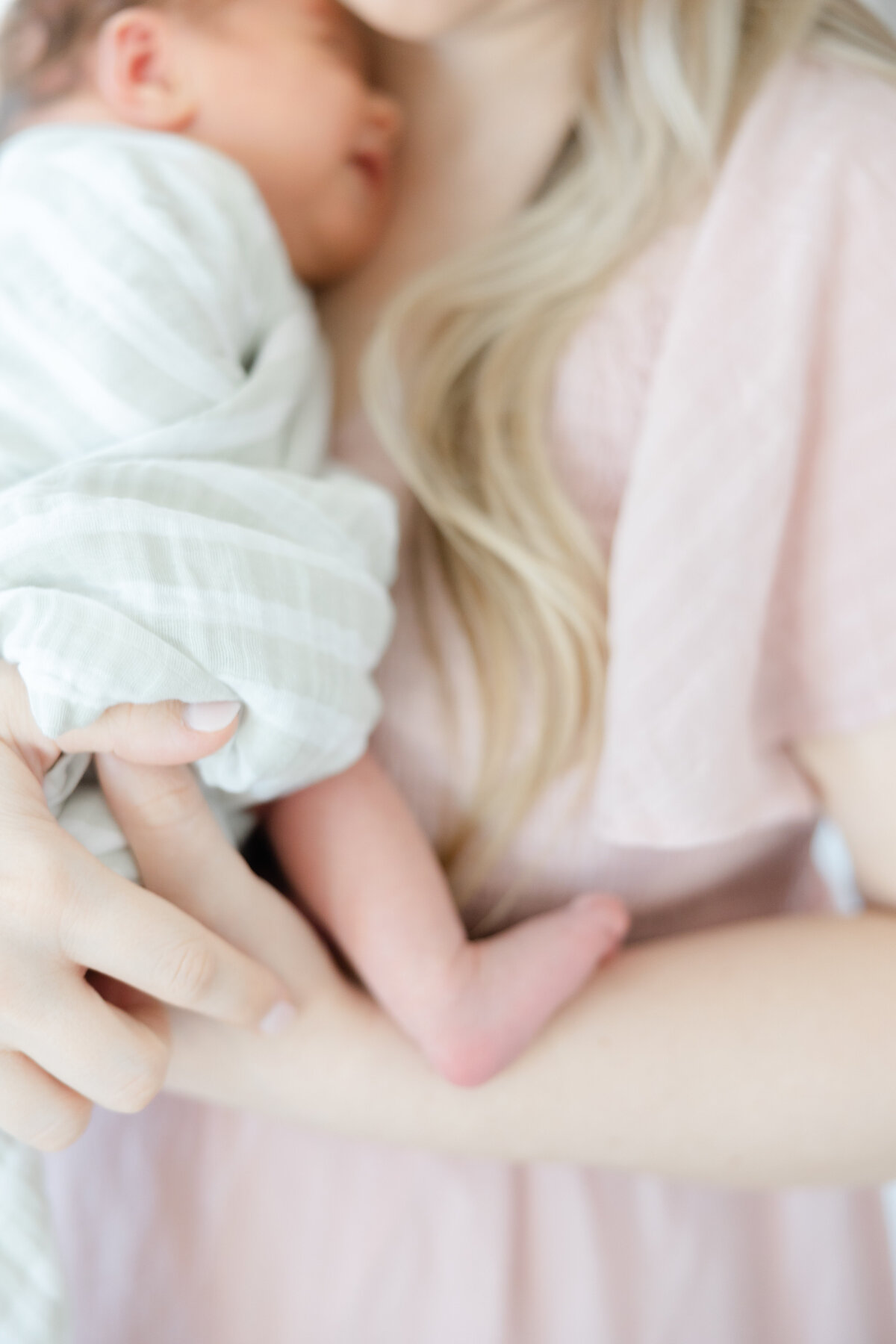 close up image of baby's foot while mother holds baby