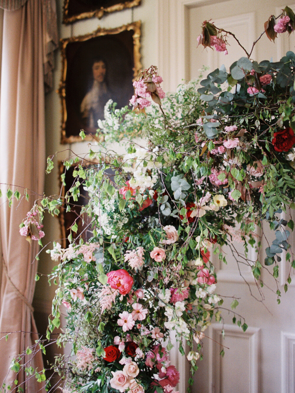 large mixed flower wedding ceremony arch for indoor wedding