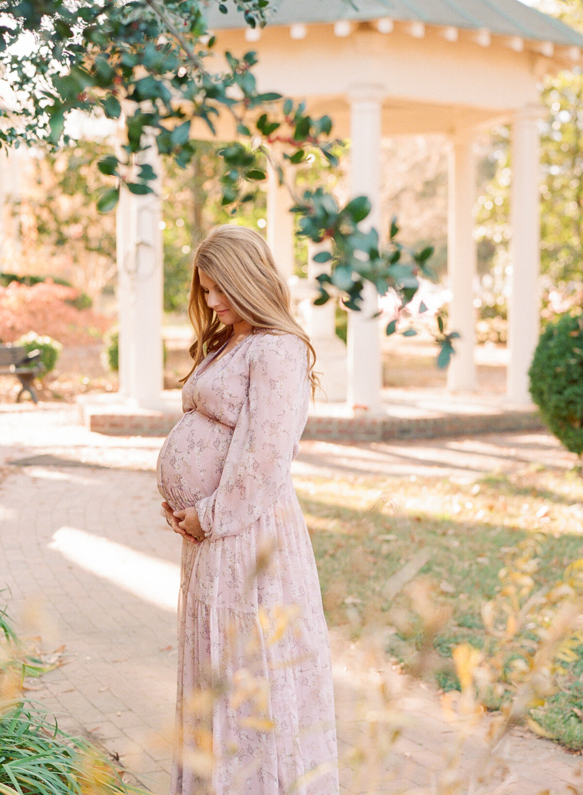 Mom staring down at her growing belly during her maternity session. Photographed by Raleigh maternity photograph A.J. Dunlap Photography.