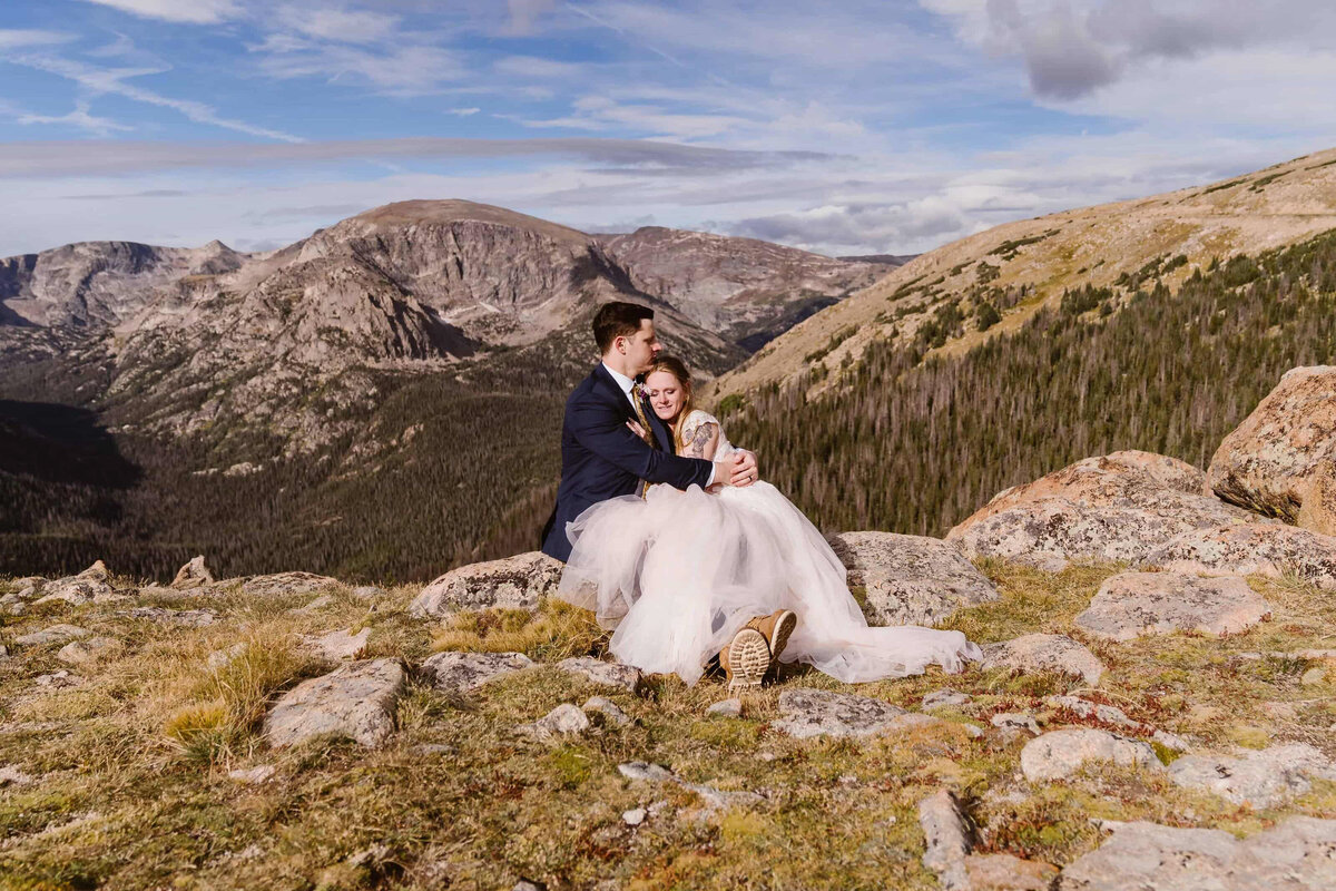 Bride and groom share a moment on a scenic overlook along Trail Ridge Road in Rocky Mountain National Park.