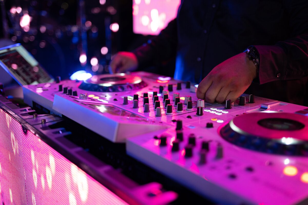 A DJ mixing music on decks at a party or corporate event.