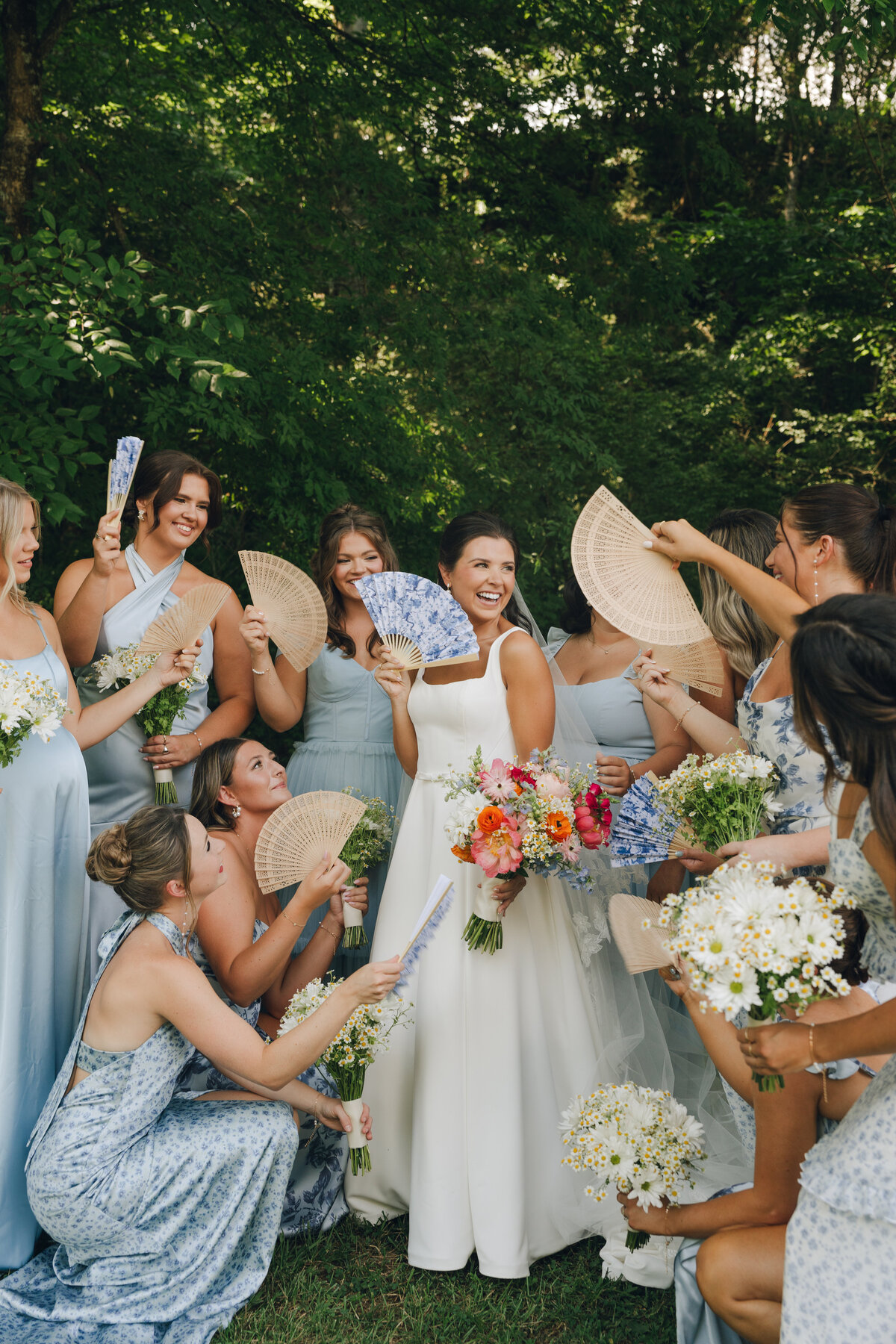 A bride and her bridesmaids surrounded by paper fans during a garden inspired wedding at Cheekwood Gardens in Nashville Tennessee.