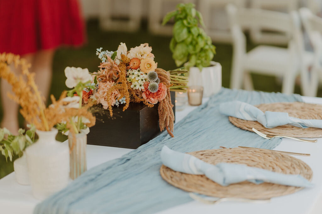 Outdoor tented wedding reception with peach and yellow flowers