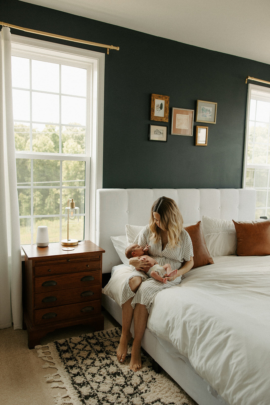 mom and son sitting on bed in master bedroom during newborn photoshoot with RVA newborn photographer