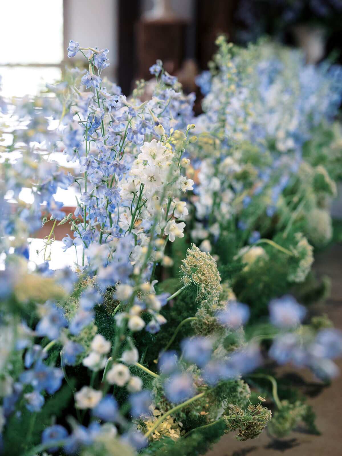 Pretty blue and white flowers adorn the wedding aisle at The Lion Rock Farm, CT. Image by Jenny Fu Studio