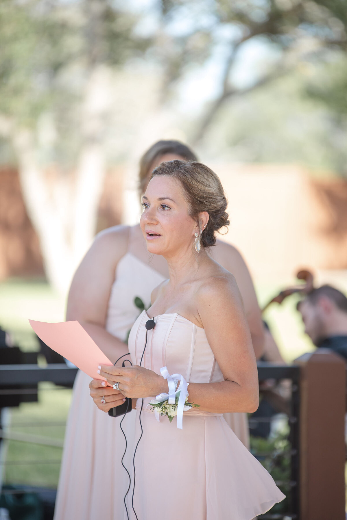 woman in peach strapless dress reads poem at Milestone Georgetown Texas wedding