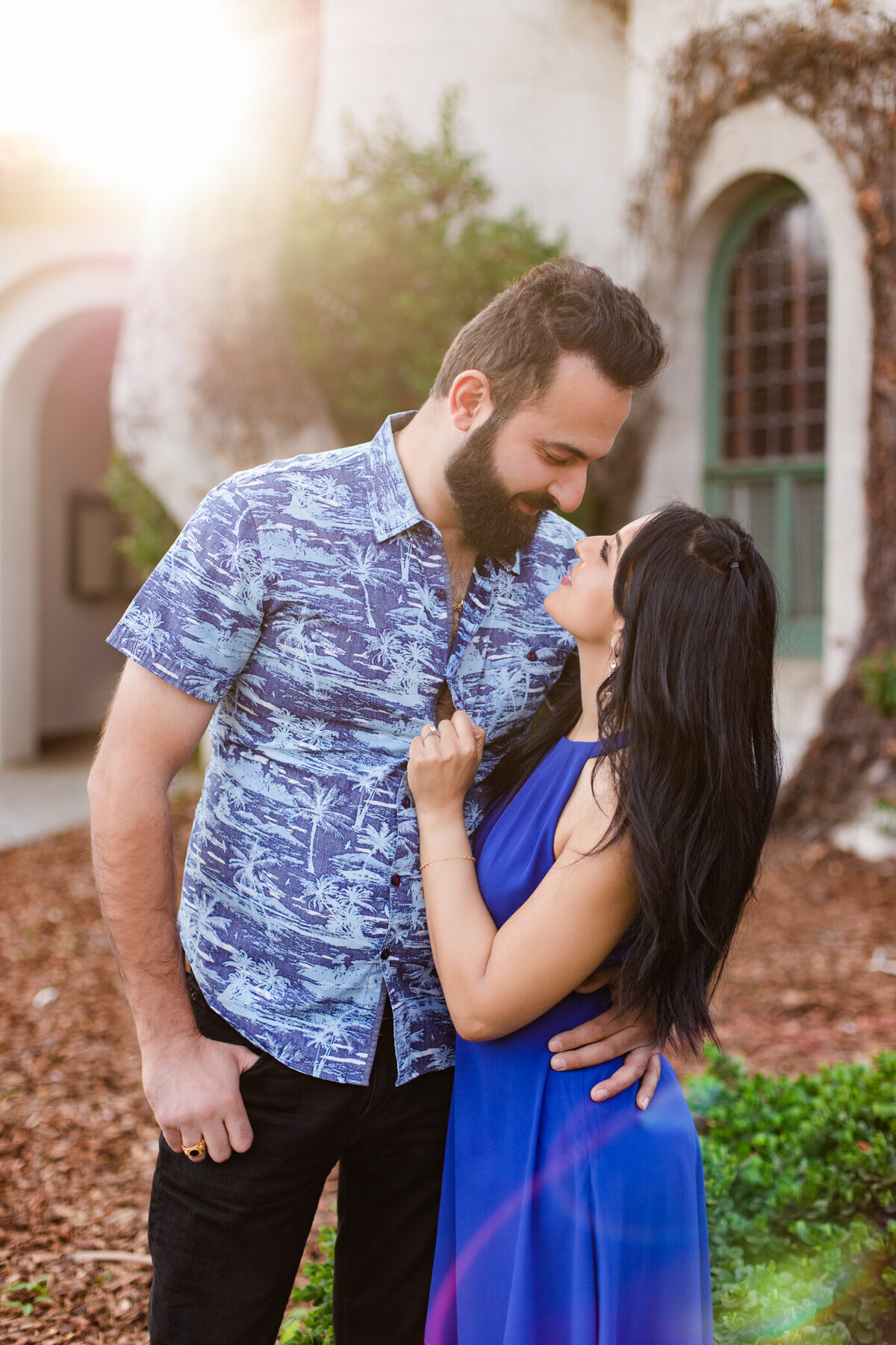 bride and groom-to-be embrace in magical sunlight