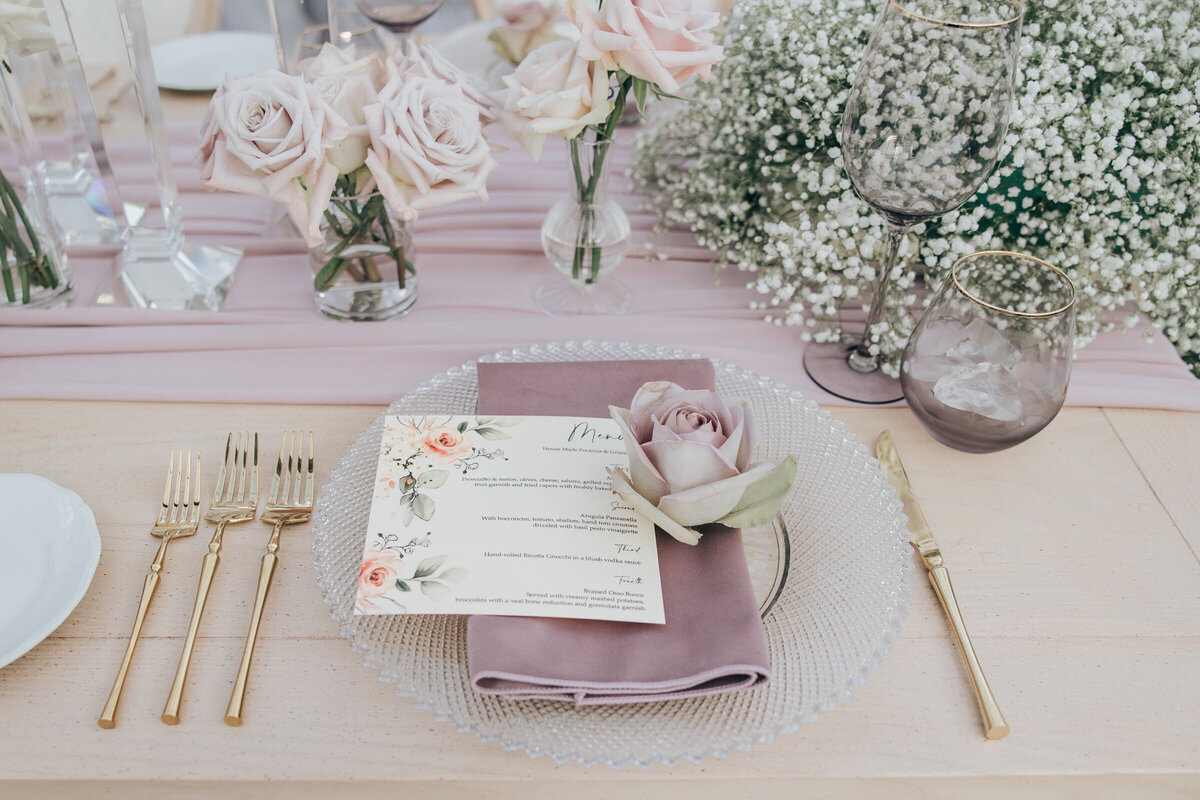 Glamorous lavender wedding table scape with gold cutlery and floral themed place cards