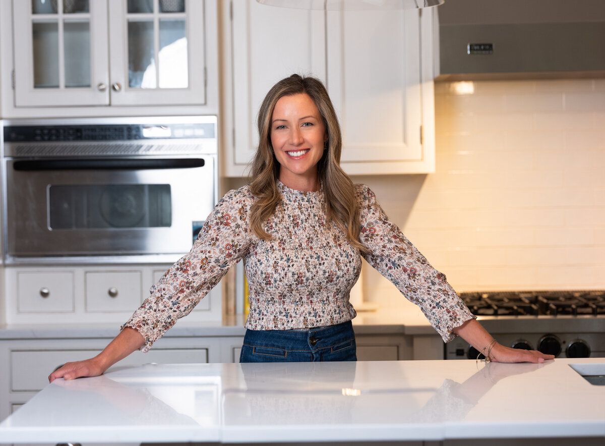 Jen, an integrative health coach, posing in her kitchen, reflecting her dedication to a healthy lifestyle and cooking for her family.