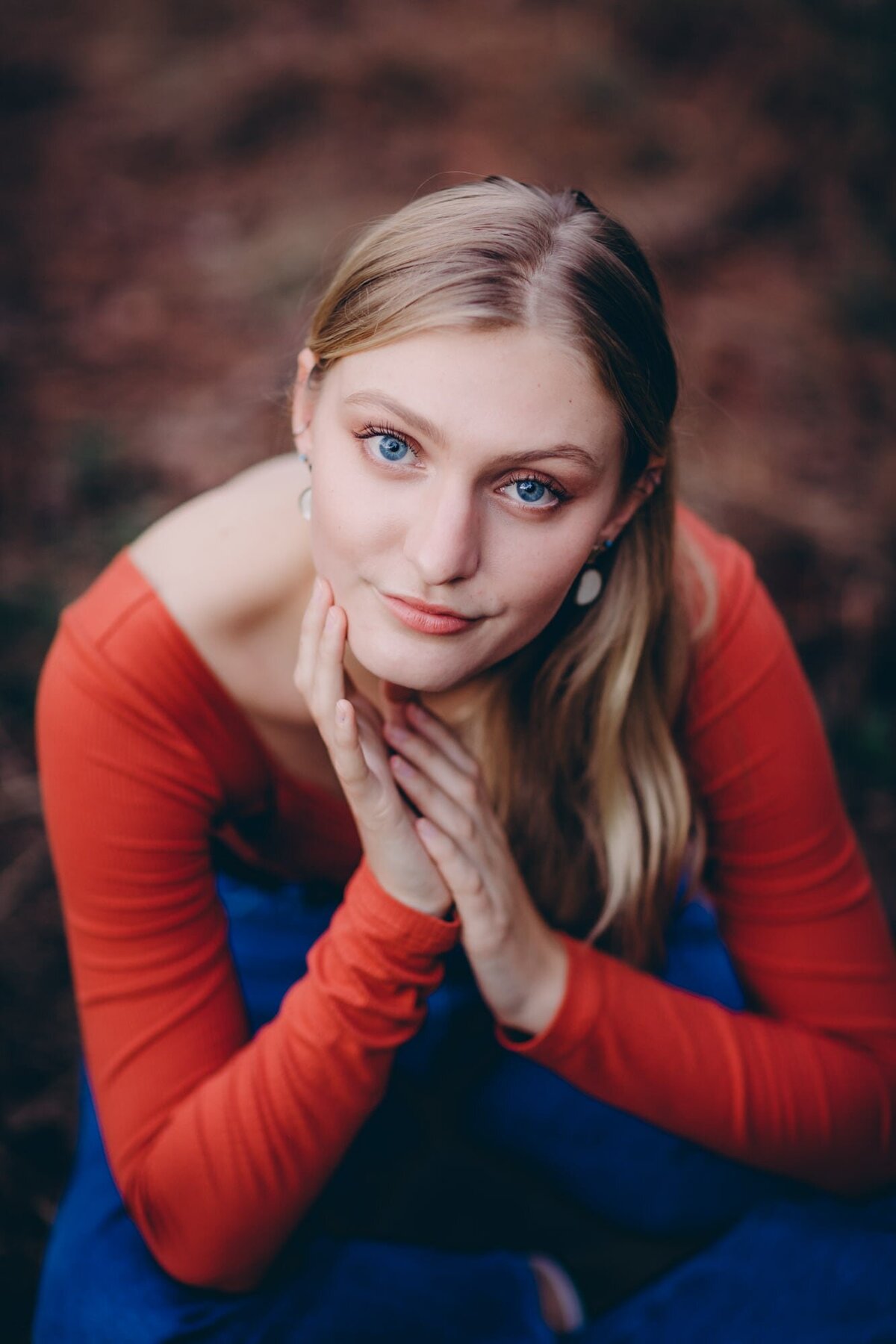 A gorgeous senior portrait of a girl in an orange shirt.