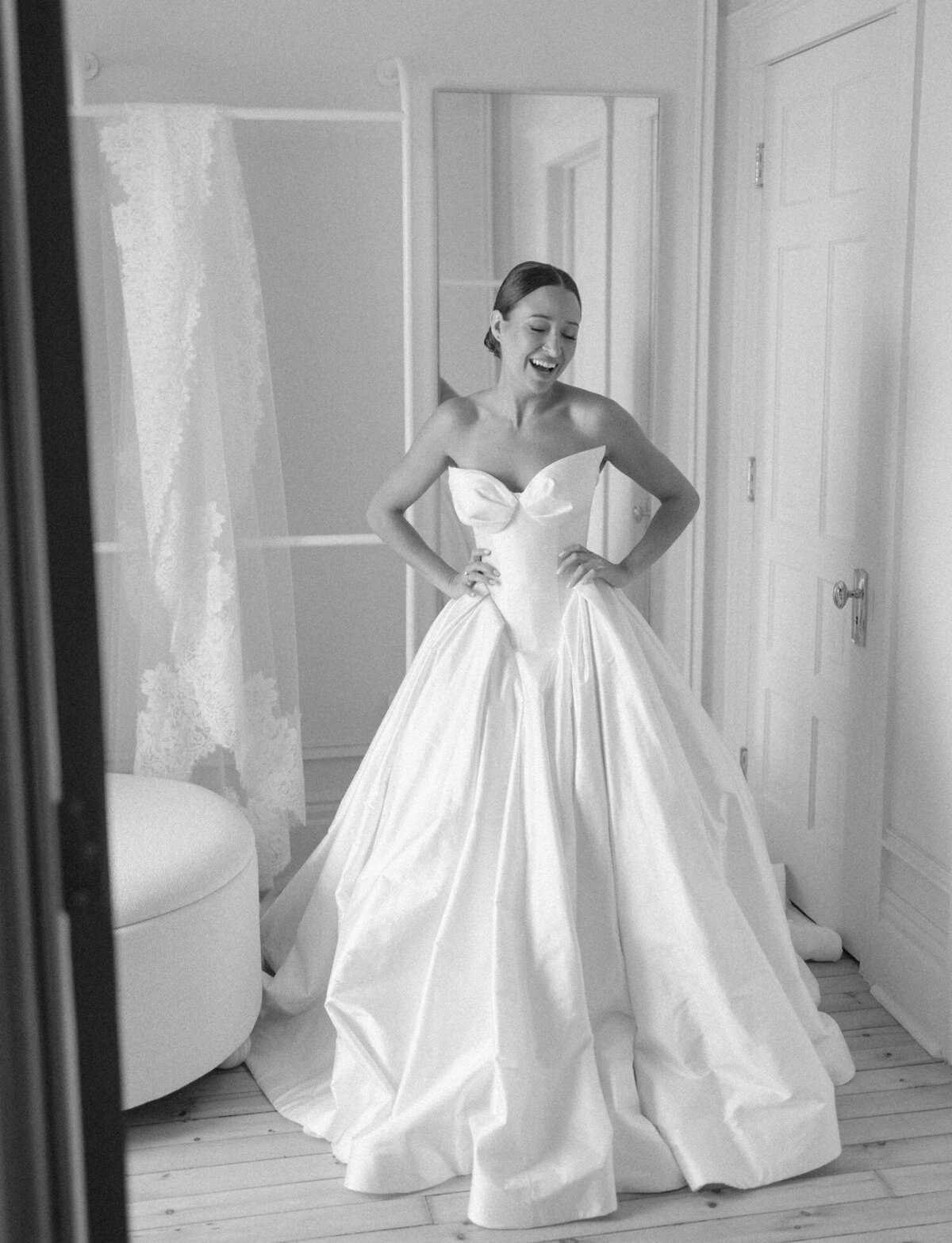 A stylish bride laughs in her stunning Leah Dagloria ballgown just before her Detroit, Michigan wedding