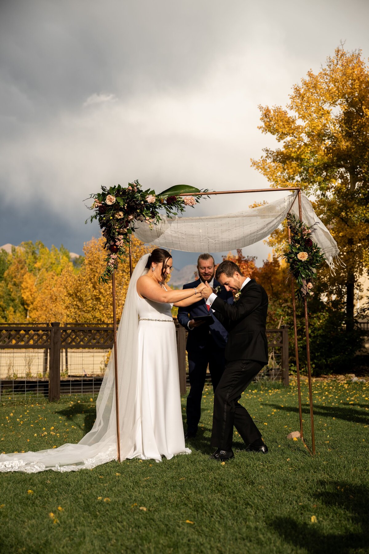 Groom breaks the glass under their chuppah during their wedding ceremony.