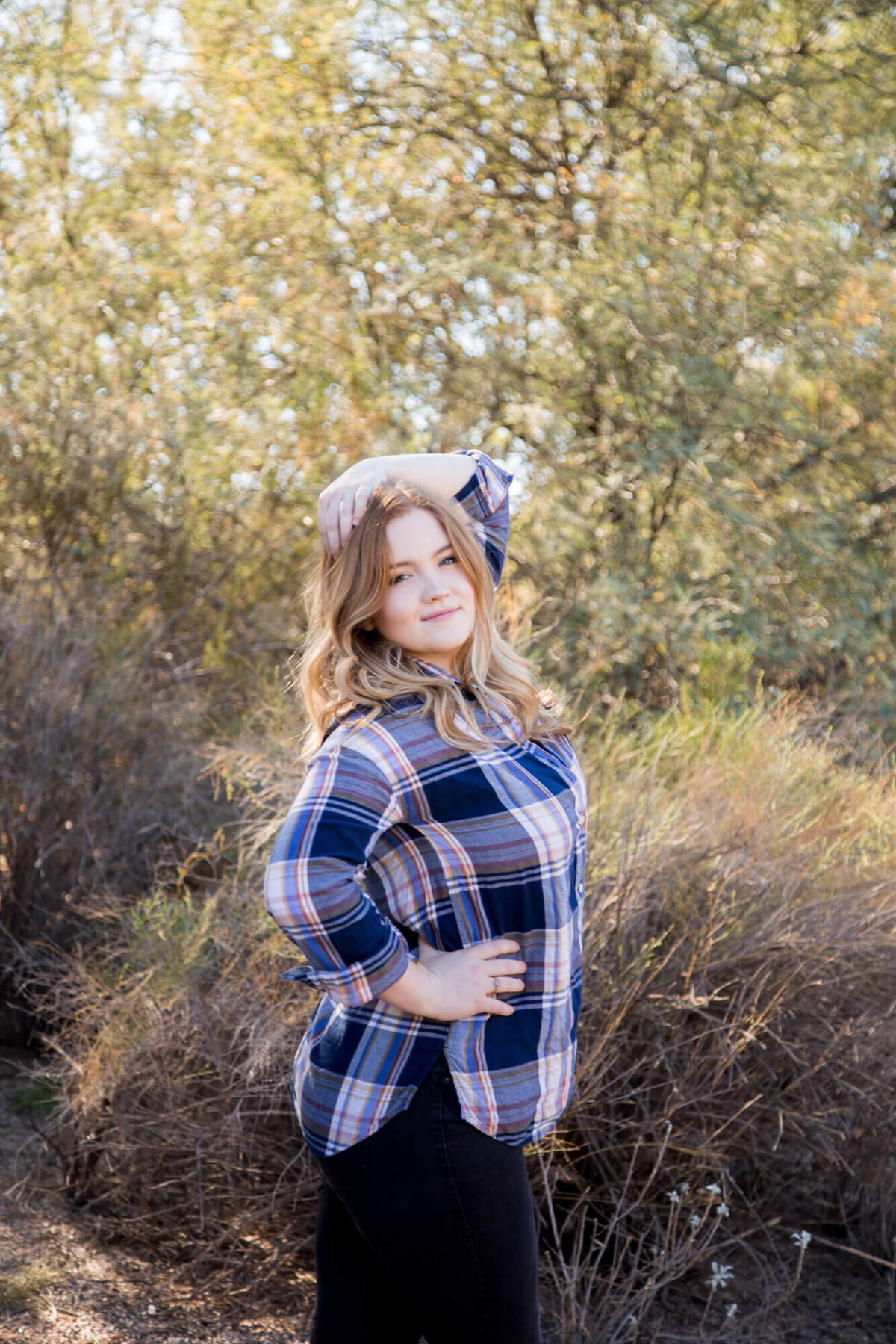 redheaded young woman posing at a park