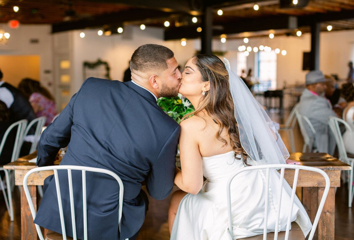 Bride and groom kissing during their reception at The Refinery at 120 in Culpeper, Virginia. Captured by Bethany Aubre Photography.