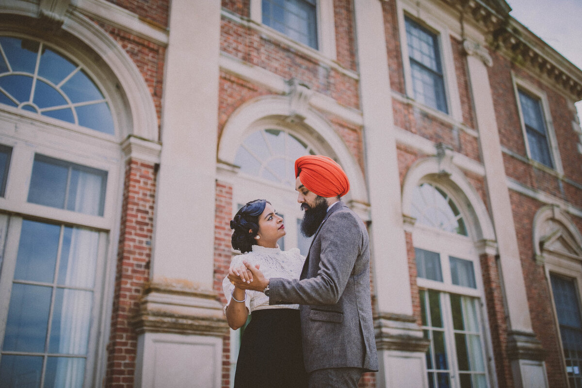 A sikh couple in vintage clothing doing a slow dance in front of the marshall field house at caumsett state park in ny