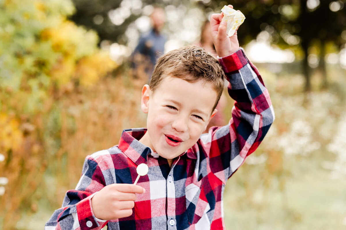 Boy taking a lollipop break during family session near Naperville, IL.