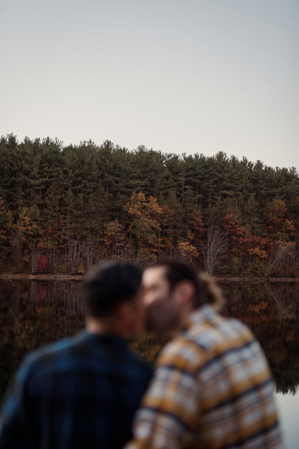 two men engagement session at a lake in the woods on a fall day. a gay couple and lgbtw friendly session. featuring a white man and asian man.