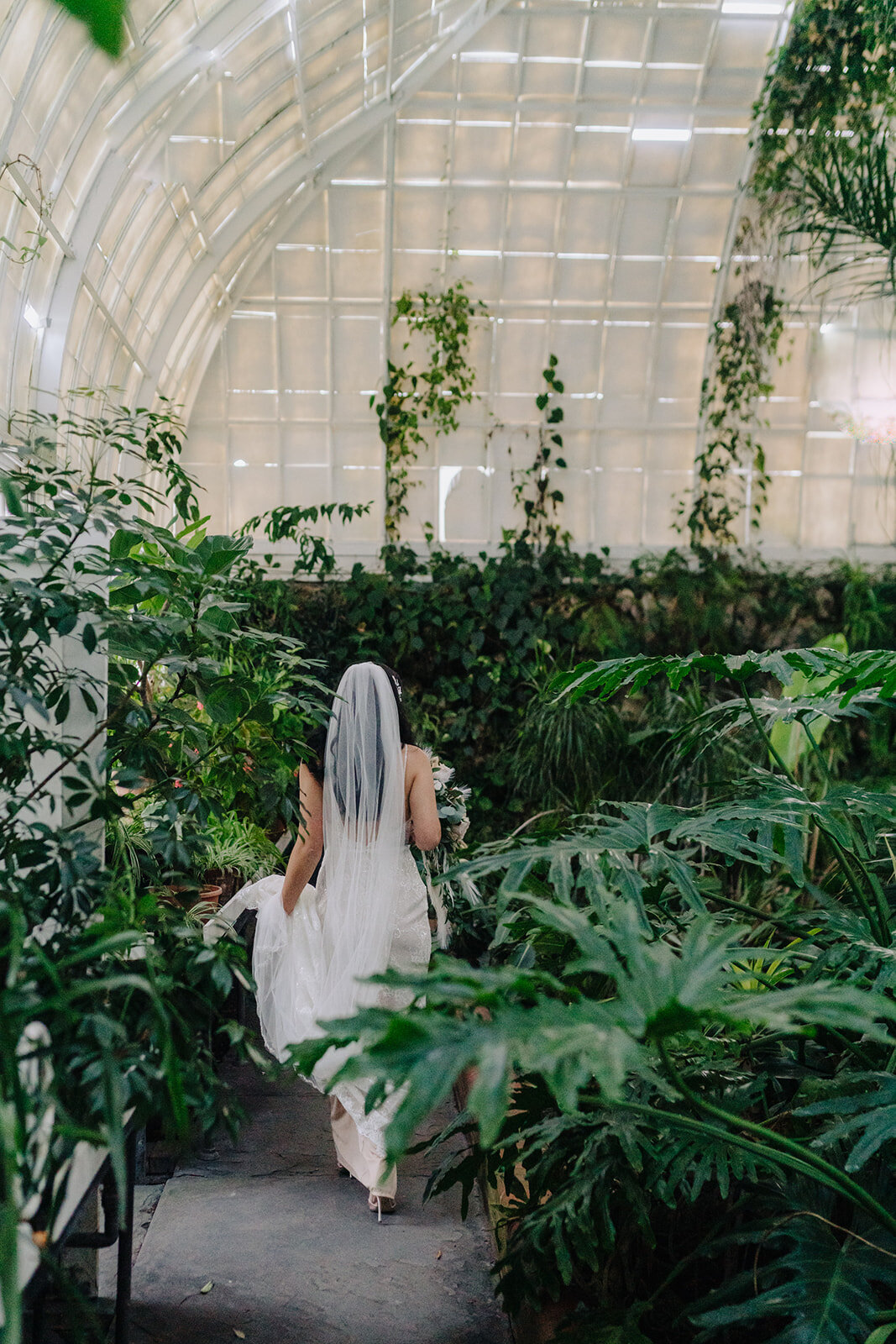 Bride walking through greenhouse at Sonnenberg Gardens in Canandaigua, NY