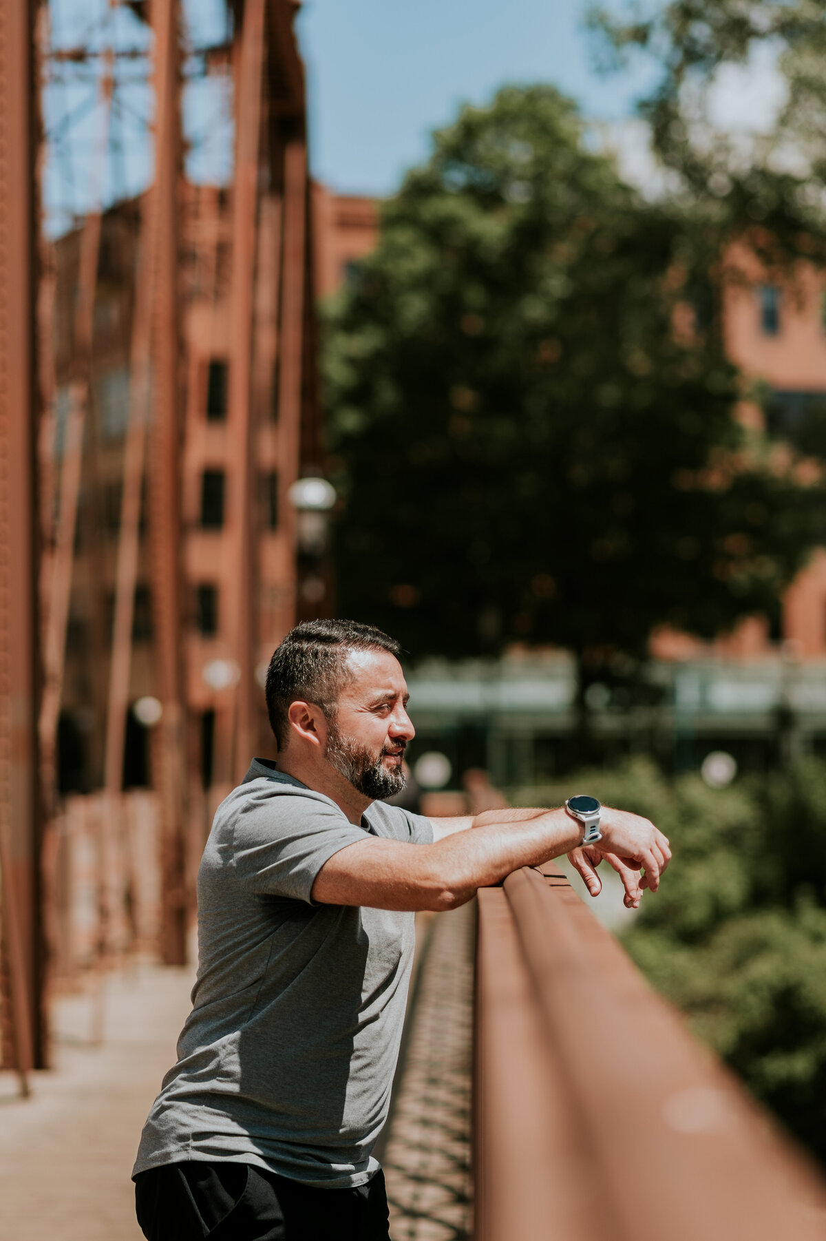 Active lifestyle dating profile photo of a man stretching outdoors on a Minneapolis bridge, ideal for dating profiles that highlight an energetic lifestyle.