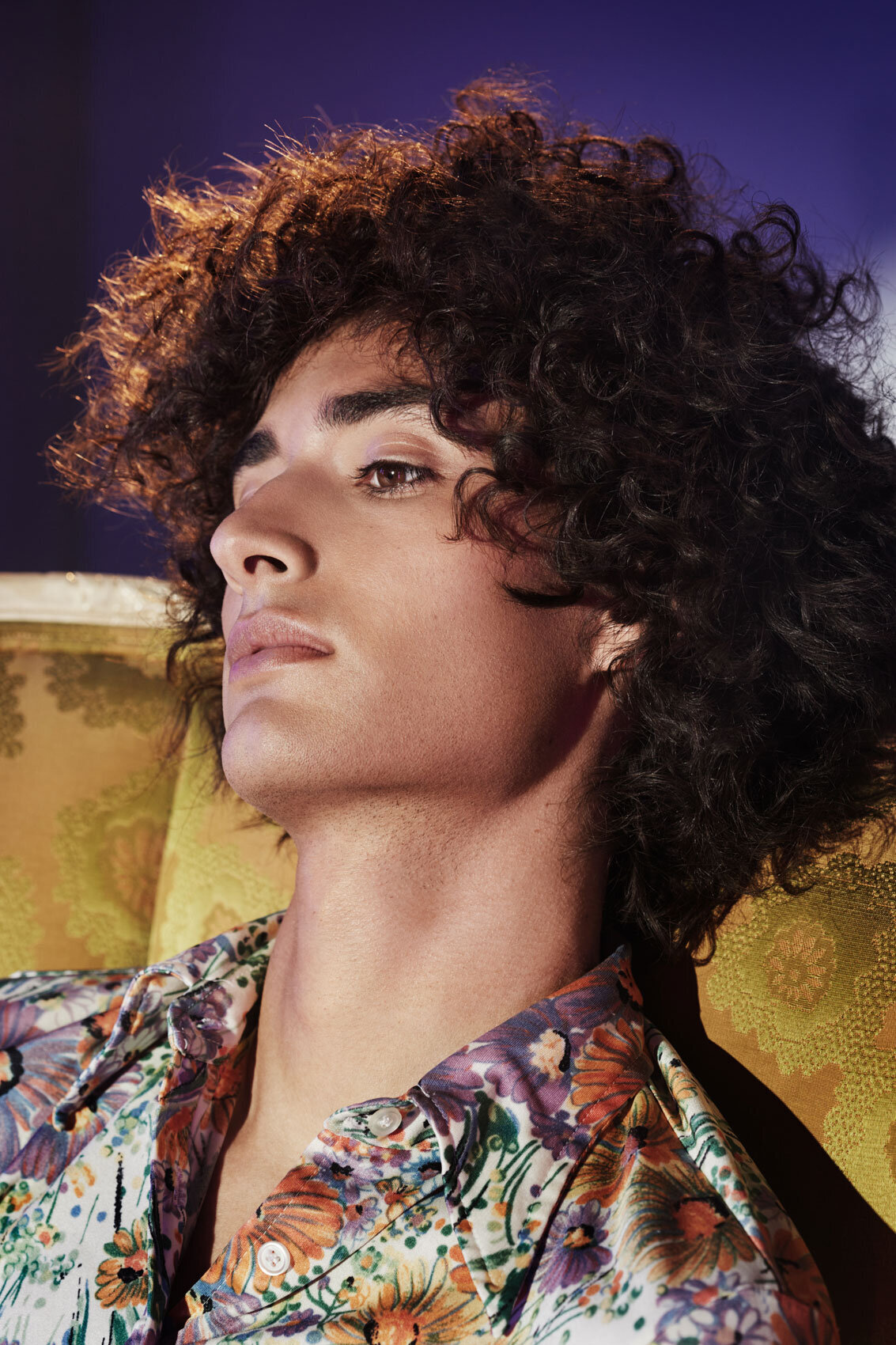 Artistic portrait of Seb Mahal with dramatic lighting, highlighting his curly hair and a thoughtful expression, by Ylva Erevall.