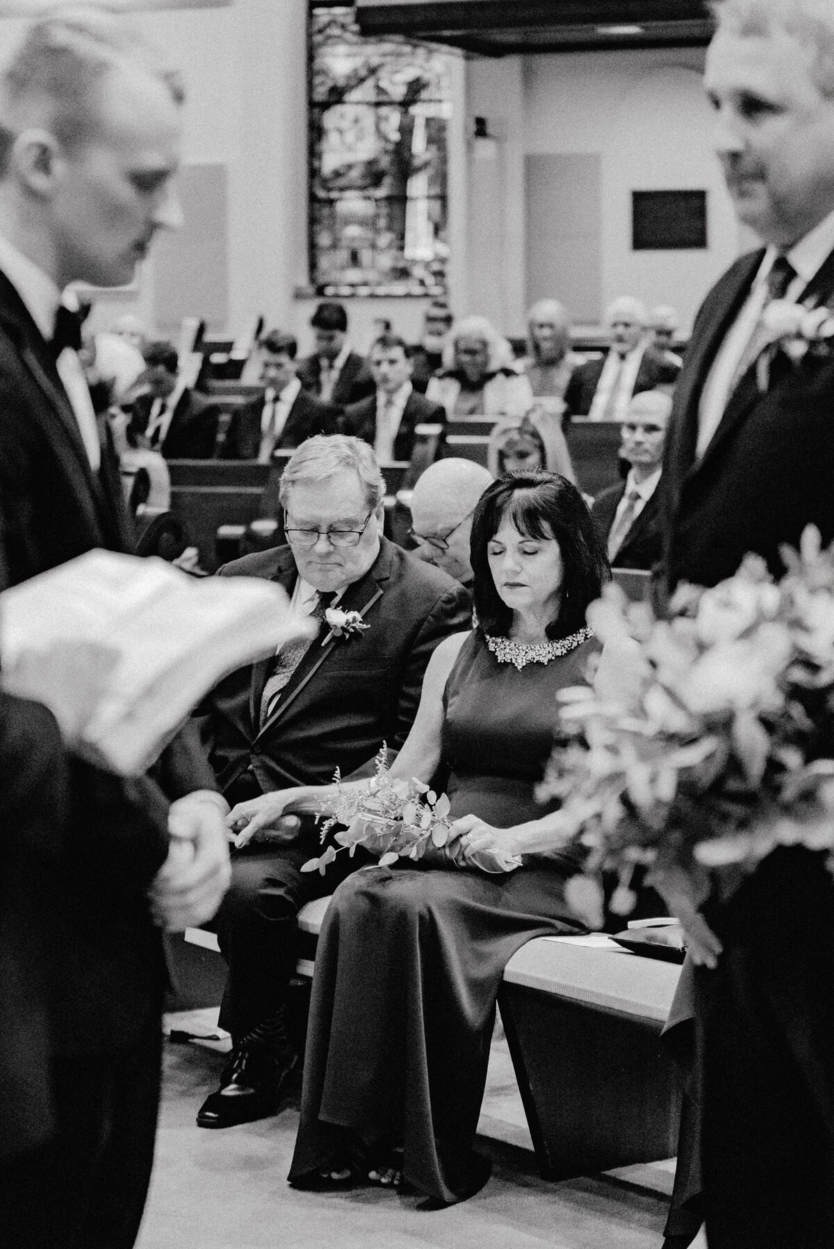 Parents of the groom in prayer during ceremony at downtown Charlottesville wedding