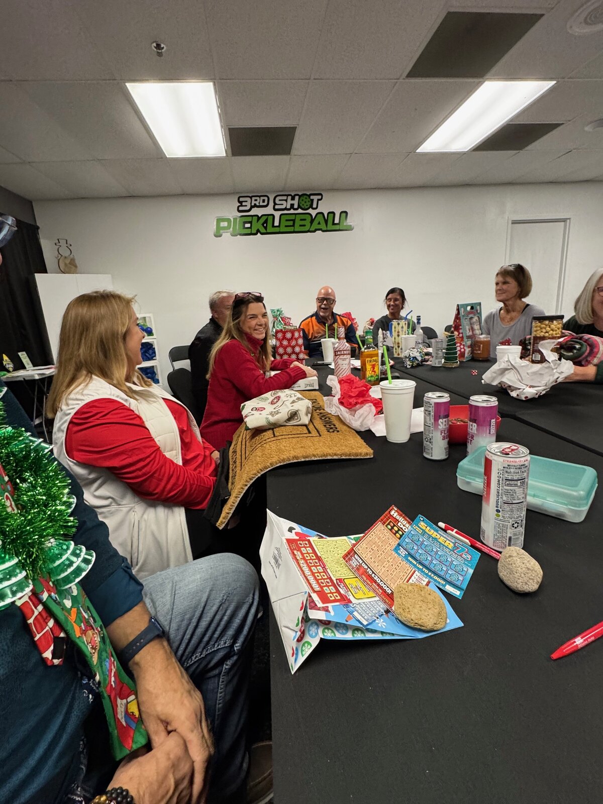 Friends sharing laughs around a table in the party room at 3rd Shot Pickleball. Ideal for celebrating birthdays, work events, and more.