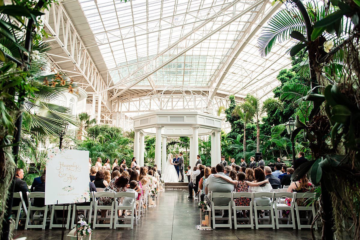 Landscape photo of the full ceremony inside the atrium under the arbor at Gaylord Opryland