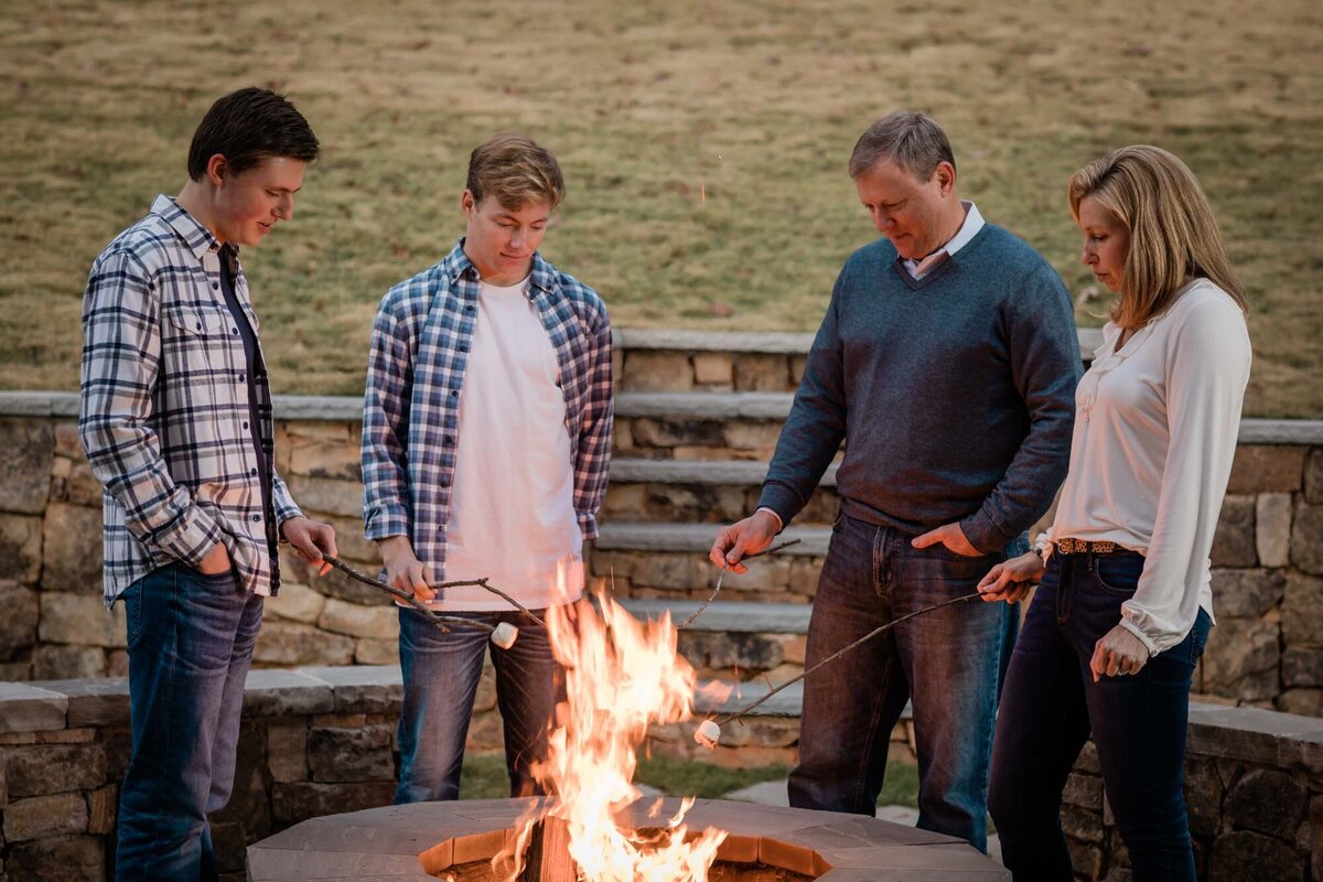 A fun family portrait around their fire pit in their back yard as they roast marshmallows.