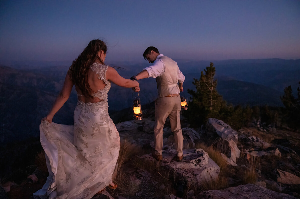 A couple with lanterns in their wedding attire during blue hour