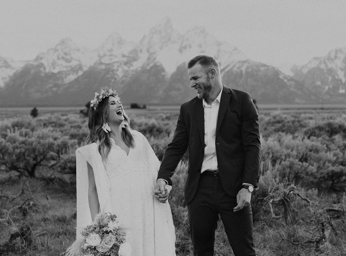 A black and white photo of a bride and groom laughing during their Jackson Hole, Wyoming wedding