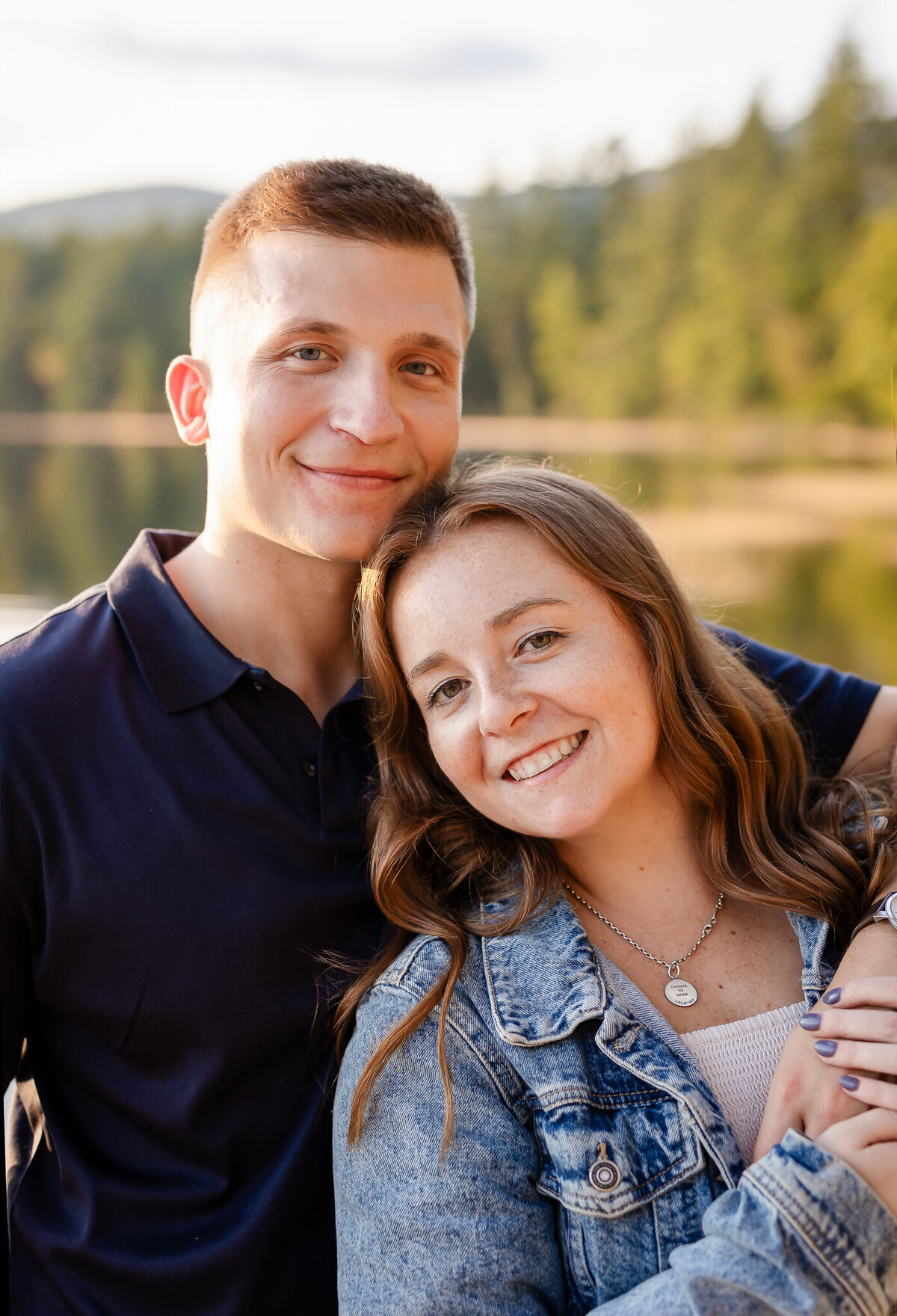 Engaged couple smiling at me at Chocorua lake engagement session