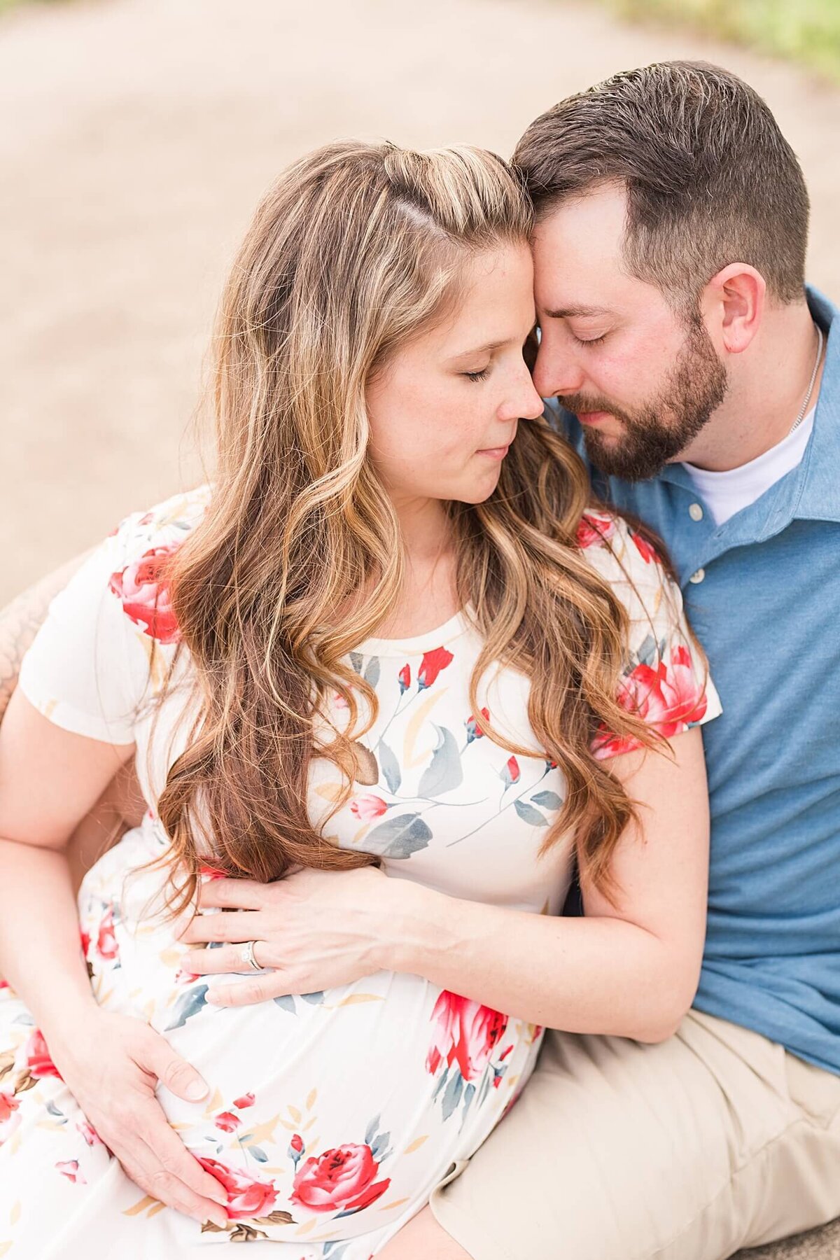 new parents to be sitting on sidewalk during maternity session in hickory nc