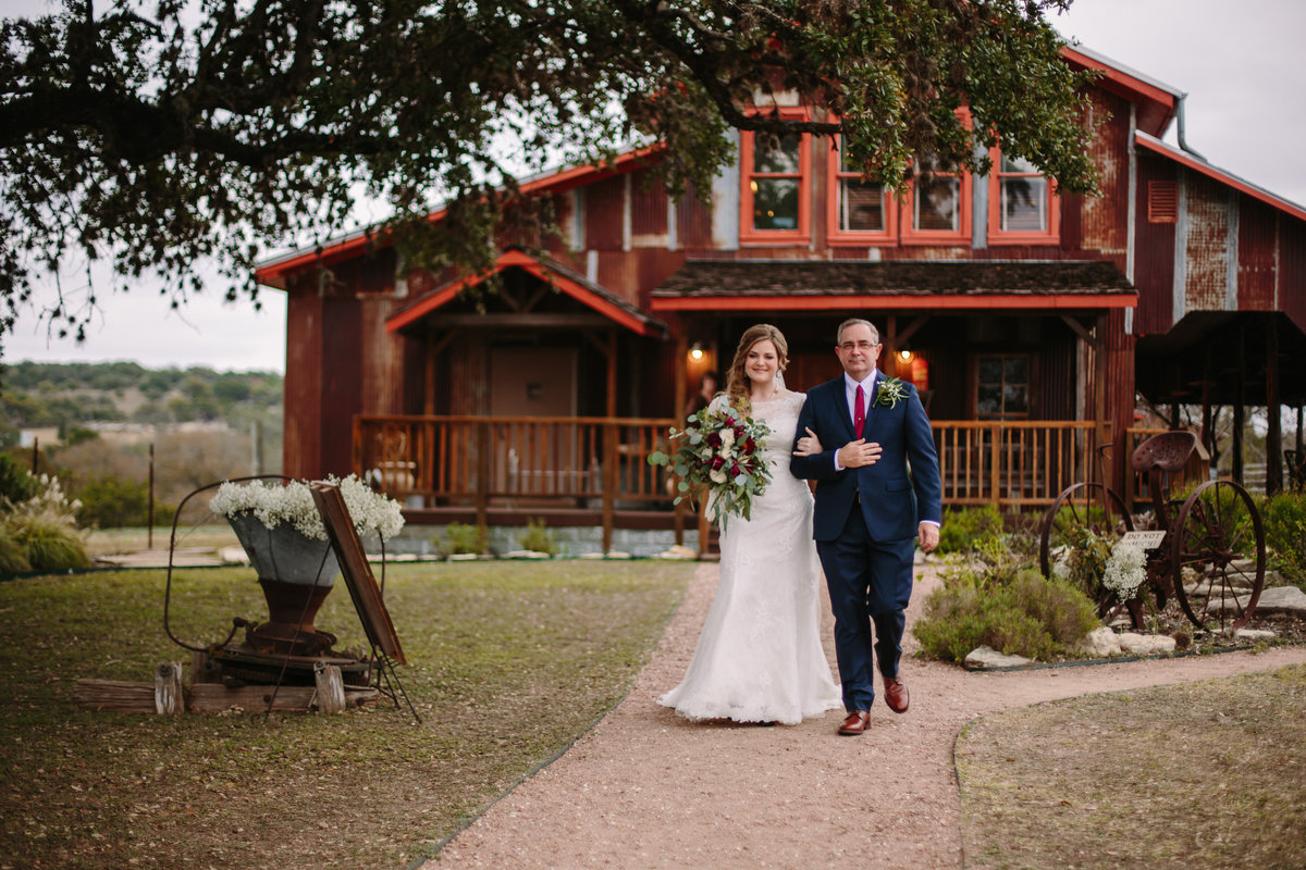 Father walking his daughter down the aisle on her wedding day at Hill Country wedding venue Welfare Cafe & Goat Barn in Boerne, Texas